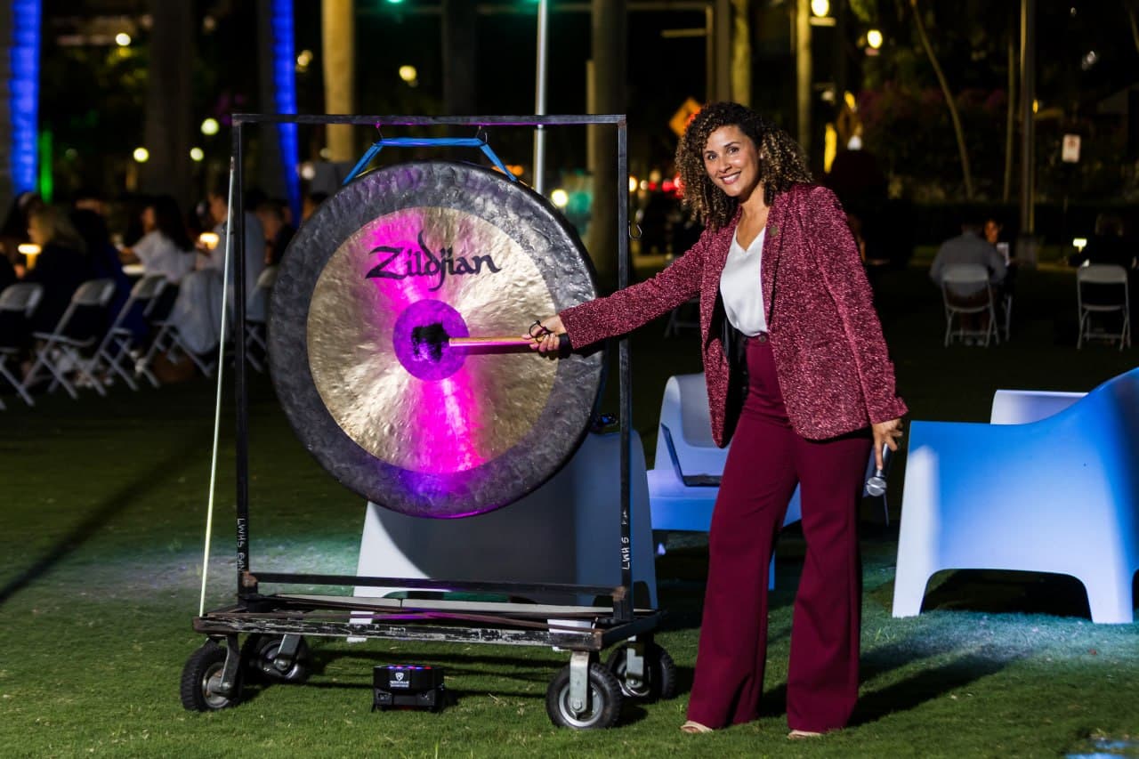 Christine Sylvain at outdoor evening event with gong ceremony