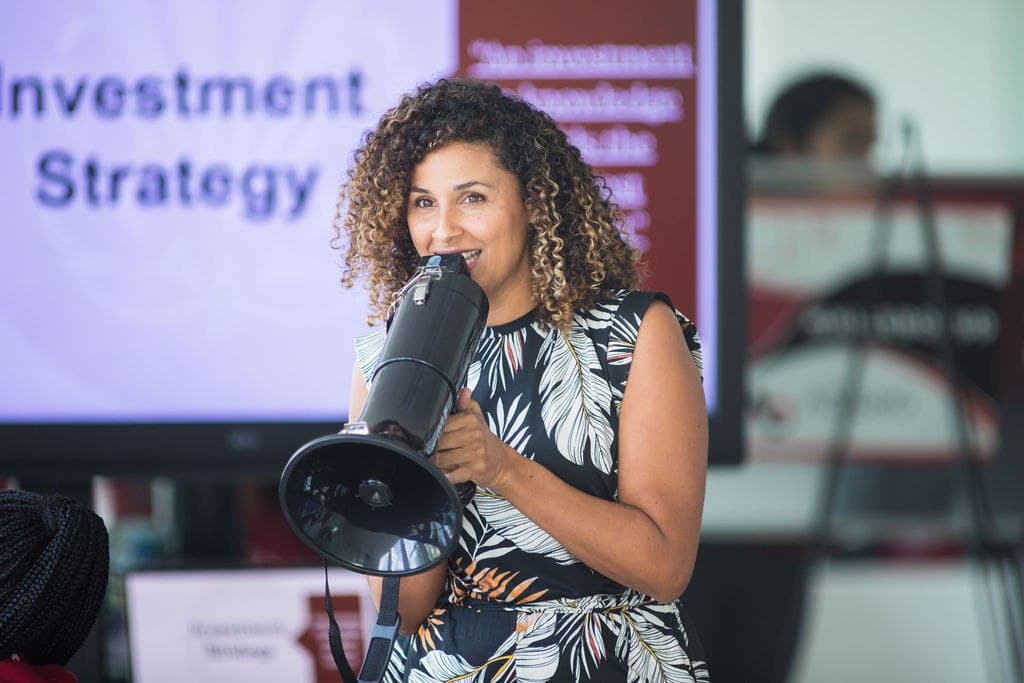Christine Sylvain speaking with megaphone at business conference